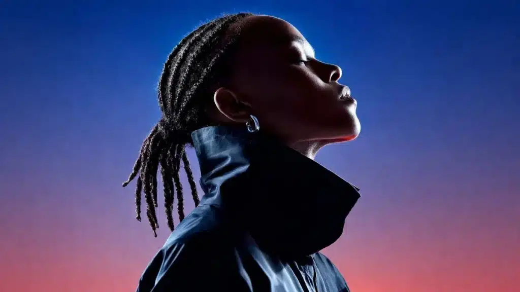 Pessoa com cabelo trançado e expressão confiante olhando para o horizonte, com iluminação em degradê azul e rosa, representando estratégia, posicionamento de marca e construção de percepção no marketing digital