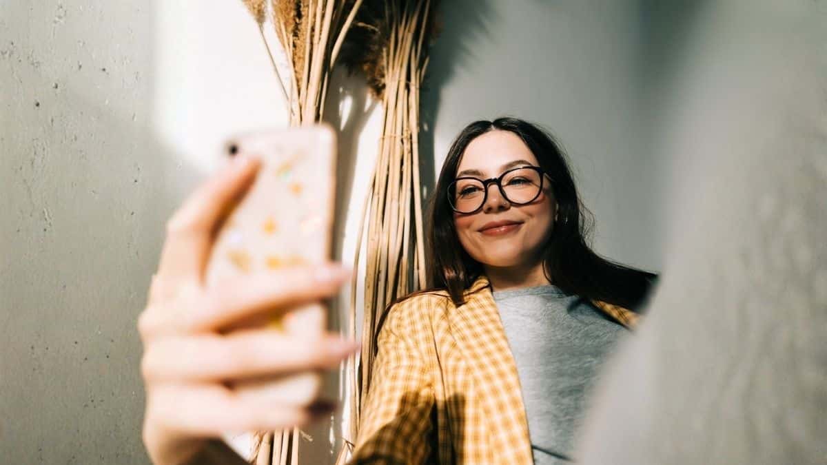 Profissional utilizando smartphone em ambiente digital, representando comportamento do usuário e tomada de decisão em campanhas de mídia programática