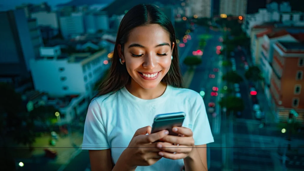 Mulher usando celular em ambiente urbano, representando eficiência de mídia digital e conexão com campanhas online.