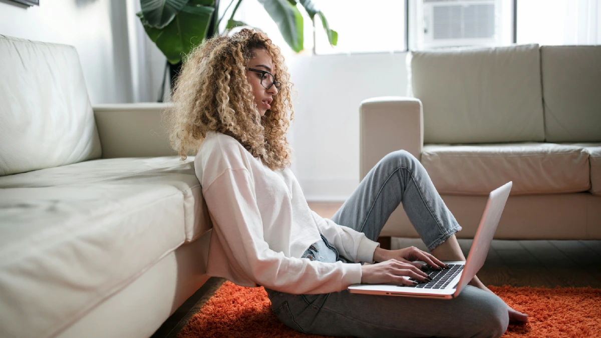 Pessoa usando notebook em ambiente doméstico, representando a mídia digital para geração de leads e a transformação de audiência online em oportunidades de negócio