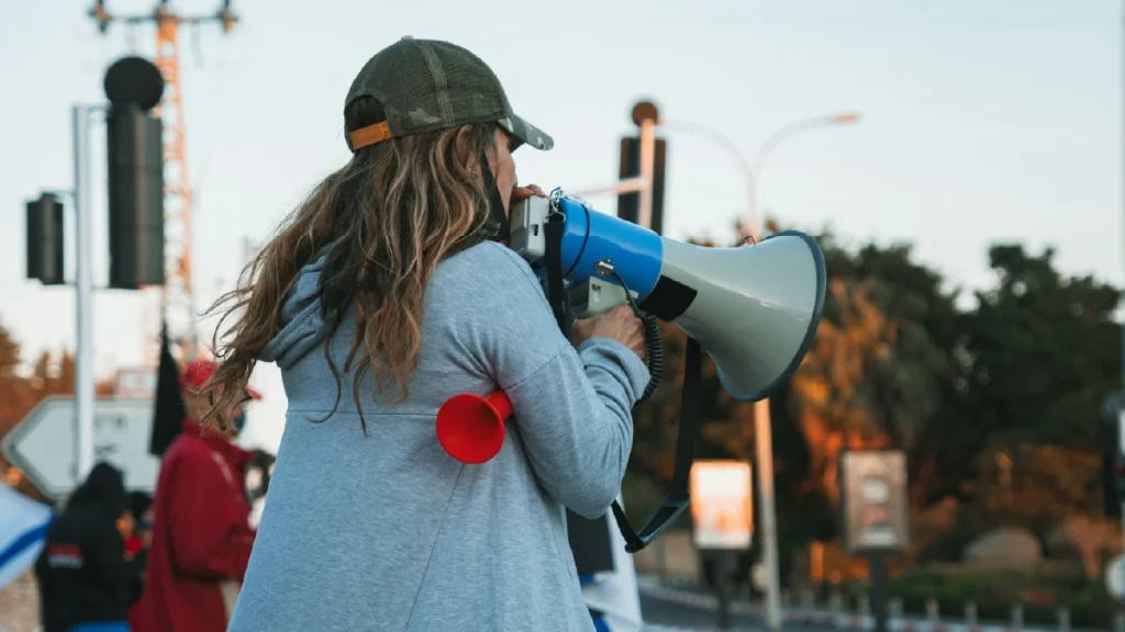 Pessoa utilizando um megafone para ampliar mensagens, representando o conceito de share of voice e visibilidade de marca